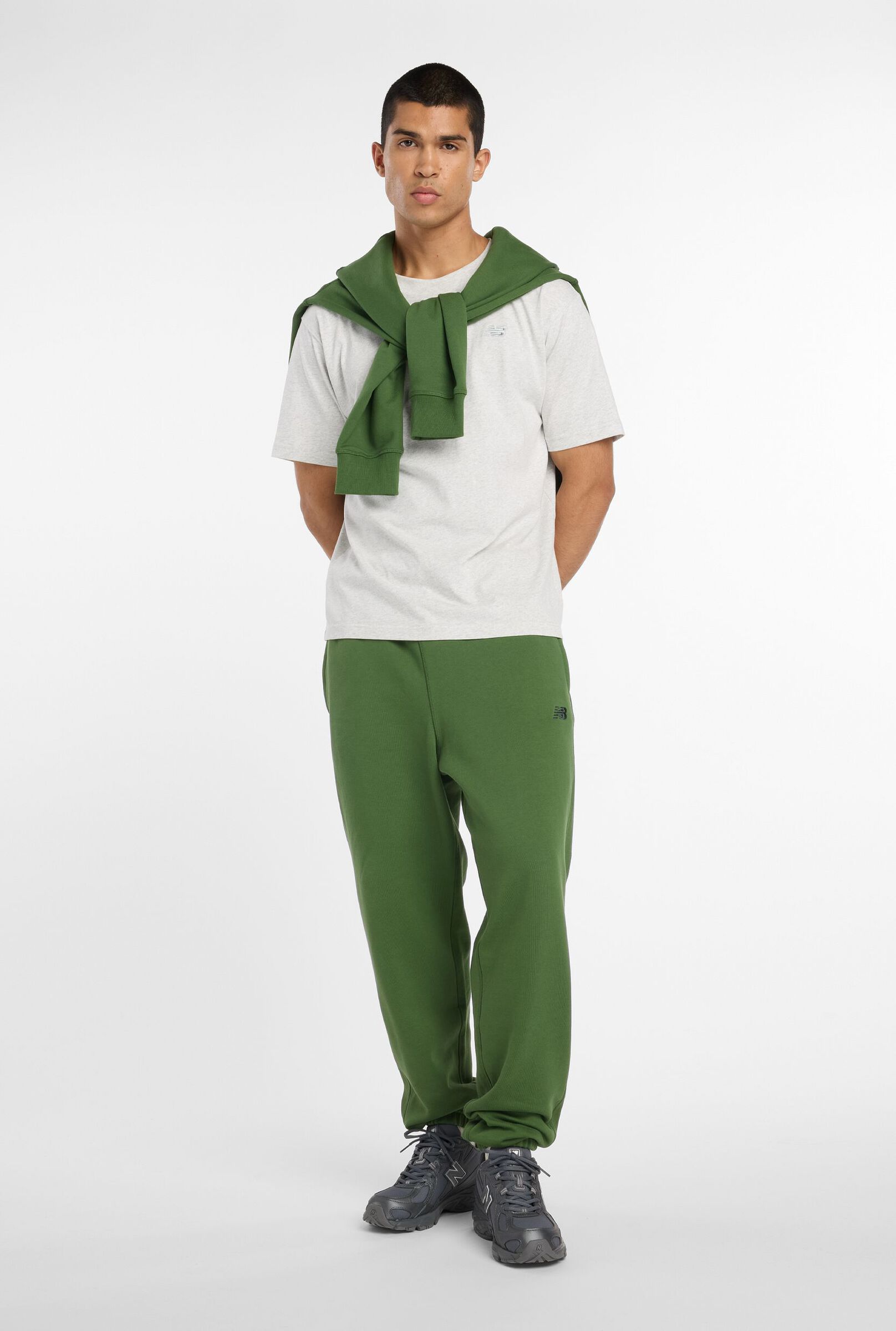 Gabby Thomas standing against a tan studio backdrop holding a pair of 471s